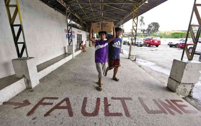 FAULT-FINDING It’s probably the scariest street sign you will encounter these days. Phivolcs staff members have painted the sidewalk outside Buli Elementary School in Muntinlupa City to mark the path of the West Valley Fault. Photo by Lyn Rillon