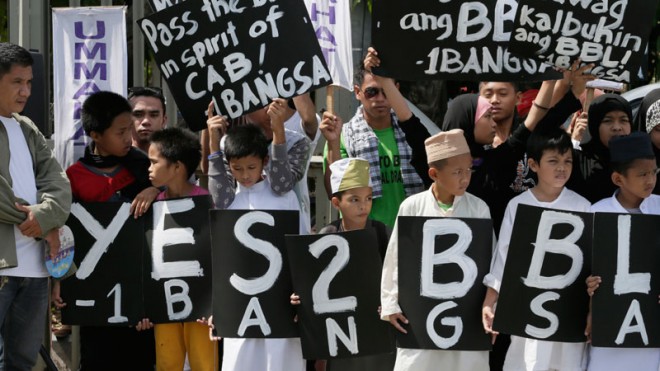Filipino Muslims display placards during a rally at the Philippine Senate to coincide with the hearing at the Upper House on the passage of the Bangsamoro Basic Law (BBL) on Monday. President Aquino on Monday offered to discuss with senators their reservations about the proposed BBL, which swiftly hurdled a House committee after a meeting with him in Malacañang.  AP PHOTO/BULLIT MARQUEZ