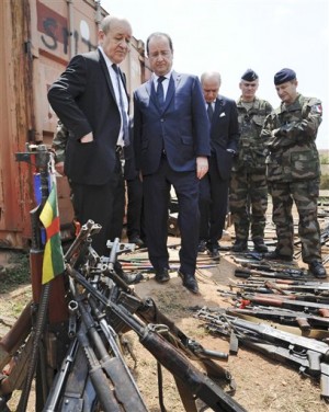 This Feb. 28, 2014 file image shows French President Francois Hollande, second from left, and French Defense Minister Jean-Yves Le Drian, left, inspecting weapons confiscated from ex-Seleka rebels and anti-Balaka militia by the French military during operation Sangaris, as they are displayed at a French military base in Bangui, Central African Republic. French prosecutors and military authorities are investigating accusations that French soldiers in Central African Republic sexually abused children they were sent to protect. AP