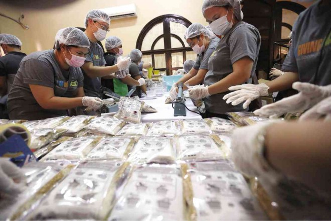VOLUNTEERS for Gota de Leche and Stop Hunger Now Philippines don protective gear to pack 36,000 meal packs containing rice, beans, dried vegetables and vitamins for malnourished children in Manila, Bulacan and the provinces of Cebu, Iloilo and Capiz.   JOAN BONDOC