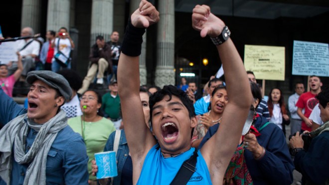 Protesters yell outside the National Palace during a protest demanding the resignation Guatemala's President Otto Perez Molina in Guatemala City, Saturday, May 23, 2015. Protesters are demanding the president step down after his Vice President Roxana Baldetti resigned earlier this month amid a corruption scandal. (AP Photo/Luis Soto)