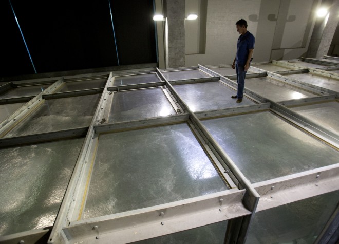 In this Tuesday, April 28, 2015 photo, Brian Haus, director of the Surge-Structure-Atmosphere Interaction, or SUSTAIN, lab, stands atop the storm simulation tank during a demonstration at the University of Miami’s Rosenstiel School of Marine and Atmospheric Science in Miami. (AP Photo/Wilfredo Lee)