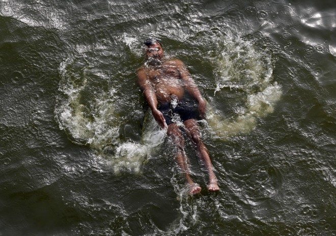 An Indian man swims in the River Yamuna on a hot summer day in Allahabad, India, Wednesday, May 27, 2015. Hundreds of people have died in southern India since the middle of April as soaring summer temperatures scorch the country, officials said Tuesday. (AP Photo/Rajesh Kumar Singh)