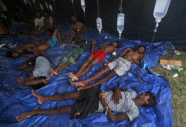 Newly arrived migrants receive medical treatment under a makeshift tent at Kuala Langsa Port in Langsa, Aceh province, Indonesia, Friday, May 15, 2015. More than 1,000 Bangladeshi and ethnic Rohingya migrants came ashore in different parts of Indonesia and Thailand on Friday, becoming the latest refugees to slip into Southeast Asian countries that have made it clear the boat people are not welcome. AP