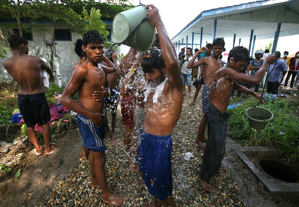 Ethnic Rohingya men take showers outside their temporary shelter in Langsa, Aceh province, Indonesia, Saturday, May 16, 2015. Boats filled with more than 2,000 desperate and hungry refugees from Myanmar and Bangladesh have arrived in Thailand, Malaysia and Indonesia in recent weeks, and thousands more migrants are believed to be adrift at sea after a crackdown on human traffickers prompted captains and smugglers to abandon their boats. AP