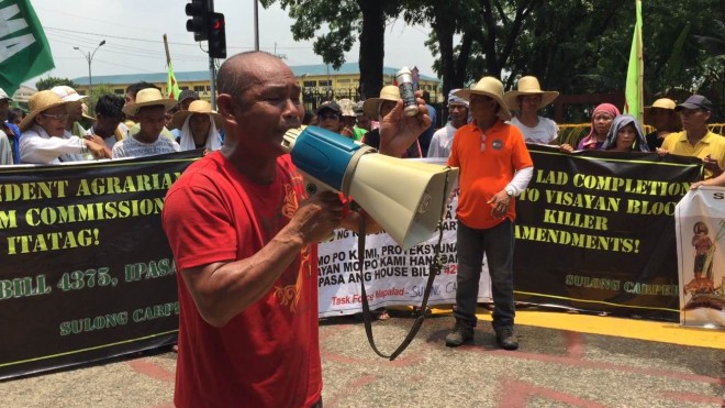 Joel Pertis, a farmers organizer from Task Force Mapalad, holds up an empty canister which he believed is the source of the tear gas that dispersed a pro-Carp rally in the South Gate of the House of Representatives.