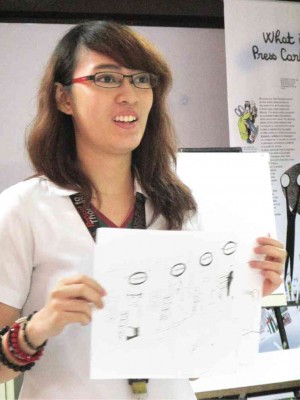 A STUDENT shows off her work at the master class at UST
