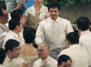 FILE - In this July 26, 2010 file photo, Filipino boxer and Congressman Manny Pacquiao greets fellow members of Philippine Congress. (AP Photo/Bullit Marquez, File)