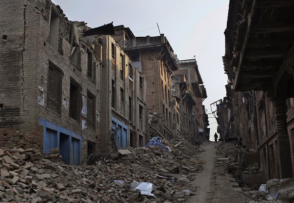 A Nepalese man walks through a path cleared with rubbles of damaged houses one month after the deadly 7.8 magnitude earthquake in Kathmandu, Nepal Monday, May 25, 2015. Two powerful earthquakes devastated Nepal on April 25 and May 12, killing nearly 8,700 people and injuring 16,800 others. The quakes and aftershocks also triggered many landslides in the Himalayan nation, which boasts eight of the world's highest mountains gets about half a million tourists every year, with many coming to trek the Himalayan nation's scenic mountain trails. AP