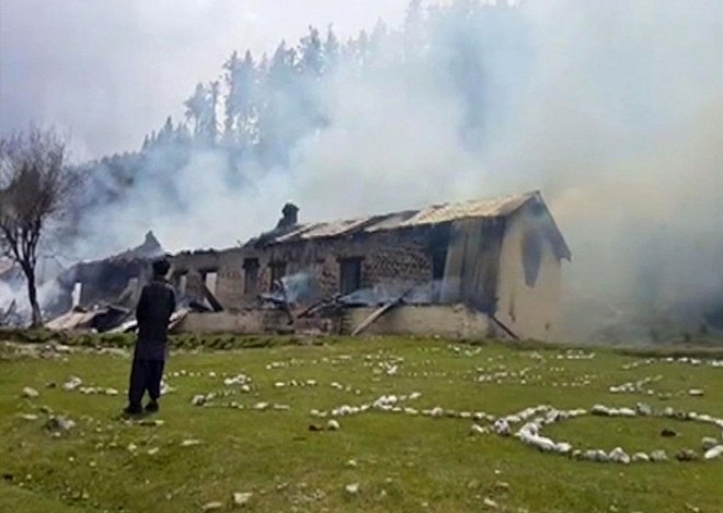 In this still image taken from video, a man watches smoke rising from an empty burning building, belonging to an army school, where a Pakistani army helicopter crashed in Nalter Valley, Gilgit, Pakistan, Friday, May 8, 2015. The ambassadors to Pakistan from the Philippines and Norway and the wives of the ambassadors from Malaysia and Indonesia were killed Friday when a Pakistani army helicopter carrying foreign dignitaries made a crash landing in the country’s north, the military said. (AP Photo)
