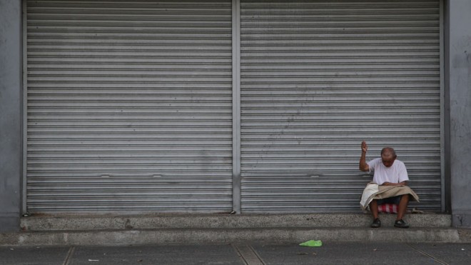 A Filipino man mends pants along a street in Manila on Sunday, April 19, 2015. About 11.4 million families remained poor in the first quarter of the year, while some 7.9 million Filipinos rated themselves food-poor, according to the latest Social Weather Stations (SWS) survey.  AP PHOTO/AARON FAVILA