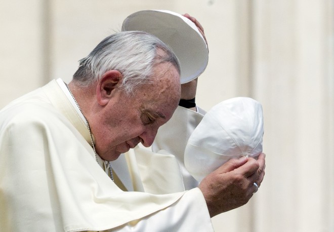 Pope Francis exchanges his skull cap with one donated to him, as he leaves at the end of his weekly general audience, in St. Peter's Square, at the Vatican, Wednesday, May 27, 2015. (AP Photo/Andrew Medichini)