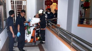 Singapore Civil Defence Force personnel wheeling the man out of his Jurong West Street flat after his right hand was stuck in the drainage trap of his master bedroom toilet. Photo by Lianhe Haobao/Straits Times/Asia News Network