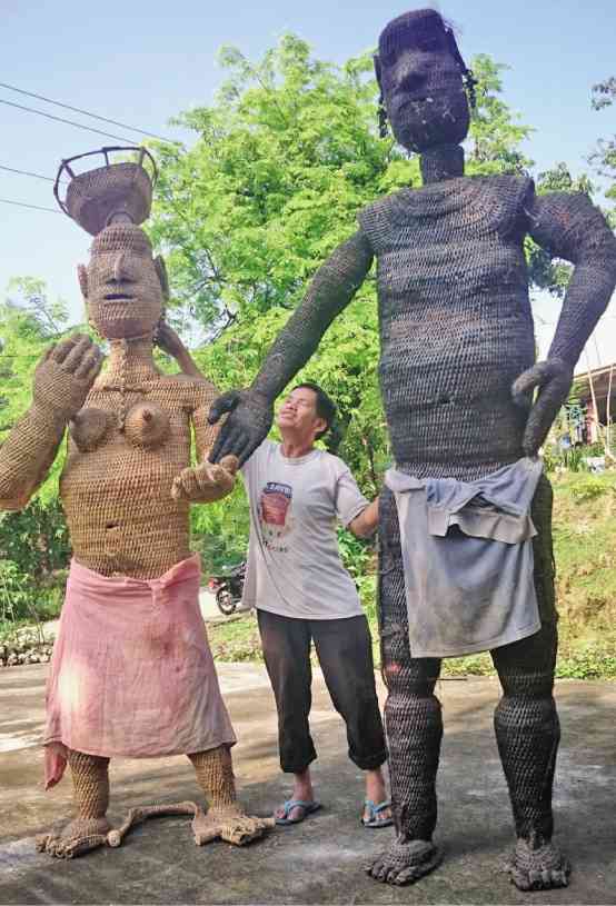 BLIND weaver Rogelio Guinannoy shows off his latest creations—a pair of woven rattan statues of Wigan and Bugan, gods of the Ifugao folklore.   MELVIN GASCON 