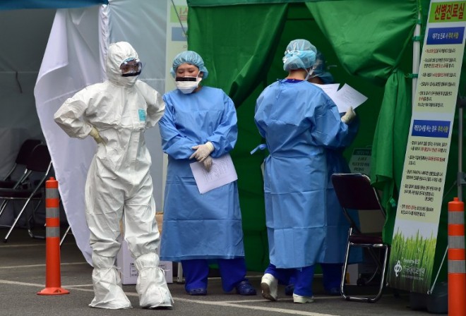 South Korean medical workers wear protective gear at a separated clinic center for MERS at Konkuk University Hospital in Seoul on June 24, 2015. Two major hospitals in South Korea's capital suspended services to patients on June 24 in a bid to stop the spread of MERS after four new cases of the deadly virus were reported.  AFP PHOTO / JUNG YEON-JE
