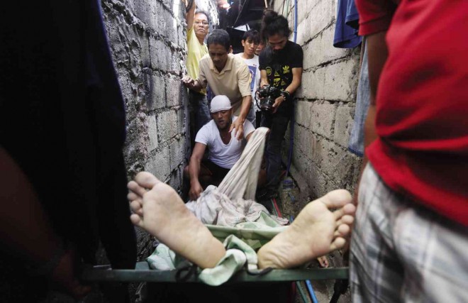 LONE CASUALTY  Neighbors view the body of Emar Allahon Asuad, 26, after the morning raid in Barangay Culiat. 