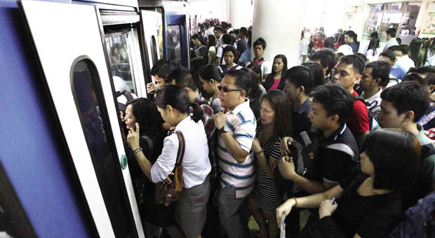 Long queues of passengers make their way inside an MRT train. FILE PHOTO
