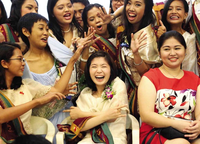 RECORD-BREAKER CHARMER    University of the Philippines student Tiffany Grace Uy (center) horses around with her classmates during the recognition rites at the Institute of Biology on Friday.  The summa cum laude  graduate,  the daughter of doctors, will pursue medical studies in August because “a doctor makes me feel safe.” MARIANNE BERMUDEZ