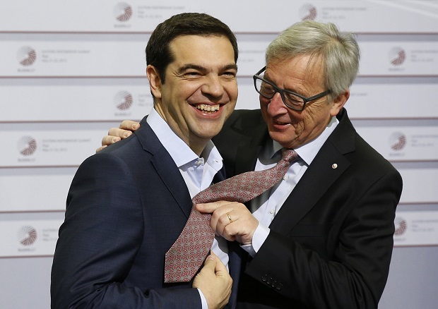 FILE - In this Friday, May 22, 2015 file photo, European Commission President Jean-Claude Juncker, right, pushes his tie up against the shirt of Greek Prime Minister Alexis Tsipras during a recent meeting in Riga, Latvia. Tsipras is heading to Brussels Wednesday, June 3, 2015 to discuss his radical-left government's proposal for a long-delayed deal with Greece's creditors that Athens hopes will unlock vitally needed bailout funds. Tsipras was invited to Brussels by Juncker, with whom he was to meet for talks Wednesday evening, a Greek government official said. (AP Photo/Mindaugas Kulbis, File)