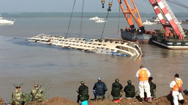 Cranes attempt to lift the capsized tourist ship Eastern Star in Jianli county in southern China's Hubei province Friday, June 5, 2015. Top-deck cabins poked out of the water from the capsized river cruise ship on the Yangtze on Friday after disaster teams righted the vessel to quicken the search for the hundreds still missing. (Chinatopix Via AP) CHINA OUT
