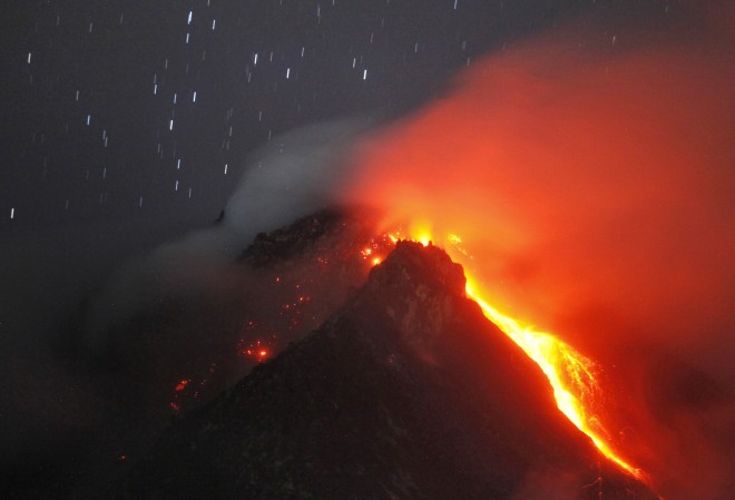 In this photo taken with slow shutter speed, hot lava flows from the crater of Mount Sinabung as seen from Tiga Serangkai, North Sumatra, Indonesia, early Monday, June 15, 2015. Authorities have been closely monitoring the 2,460-meter (8,070-foot) -high volcano since June 2 when its status was raised to the highest alert level due to the growing size of its lava dome. (AP Photo/Binsar Bakkara)