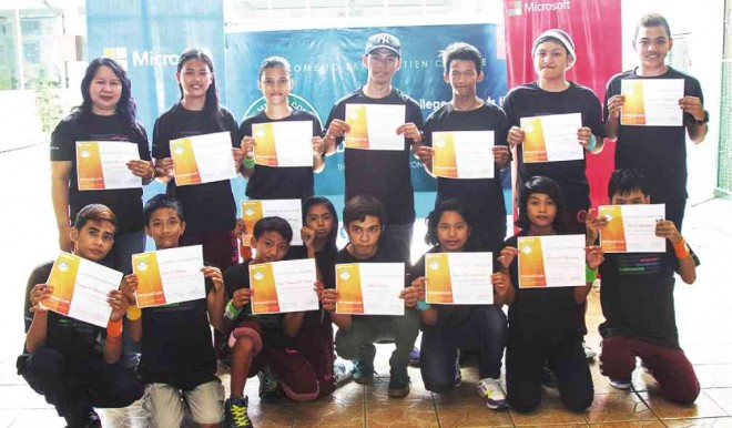 CAYA (standing, left) and her students receive certificates after completing the Microsoft Philippines computer coding workshop.