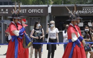 Tourists wearing masks as a precaution against MERS, Middle East Respiratory Syndrome, virus watch a ceremony at the Gyeongbok Palace, one of South Korea's well-known landmarks, in Seoul, South Korea, Sunday, June 7, 2015. A fifth person in the country has died of the MERS virus, as the government announced Sunday it was strengthening measures to stem the spread of the disease and public fear. (AP Photo/Lee Jin-man)