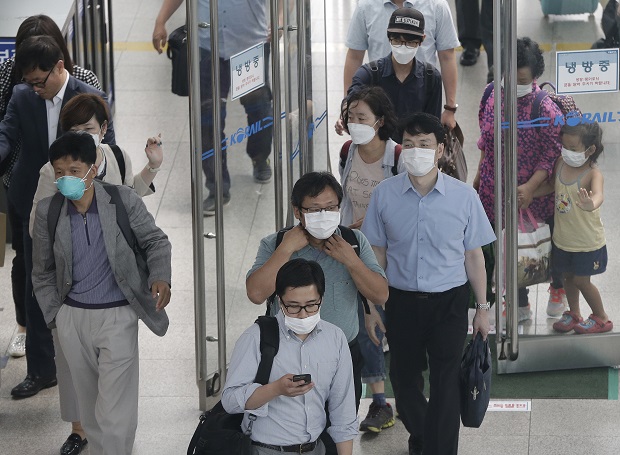 People wear masks as a precaution against MERS (Middle East Respiratory Syndrome) as they arrive at Seoul Railway Station in Seoul, South Korea, Tuesday, June 16, 2015. The death toll continued to mount in South Korea's MERS outbreak on Tuesday even as schools reopen and people recover from the virus. (AP Photo/Ahn Young-joon)