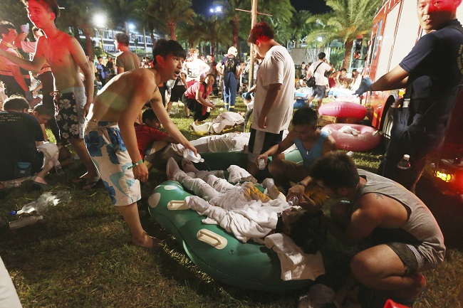 Emergency rescue workers and concert spectators tend to injured victims from an explosion during a music concert at the Formosa Water Park in New Taipei City, Taiwan, Saturday, June 27, 2015. The New Taipei City fire department says 200 people were injured in an accidental explosion of colored theatrical powder Saturday night near a performance stage where about 1,000 people were gathered for party. AP