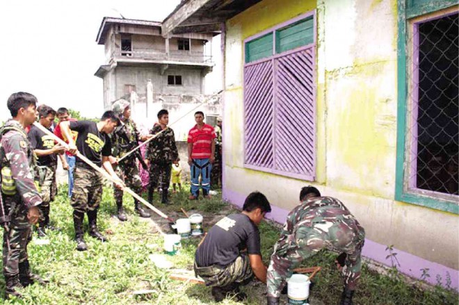 SOLDIERS belonging to the 103rd Infantry Brigade of the Philippine Army and members of the Bangsamoro Islamic Armed Forces-Moro Islamic Liberation Front repaint the elementary school building near Camp Busra in Butig, Lanao del Sur province. RICHEL UMEL 
