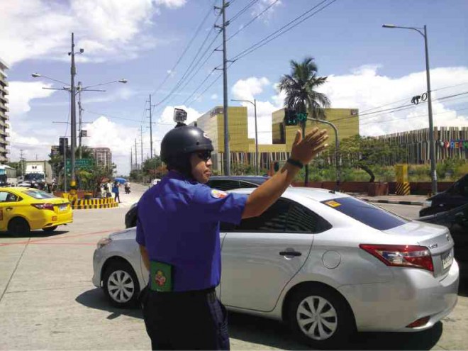 CAMERA-READY MMDA traffic constable Cesar Detera Jr. in action and ready to take a “shot” against hotheads on the road. CONTRIBUTED PHOTO 