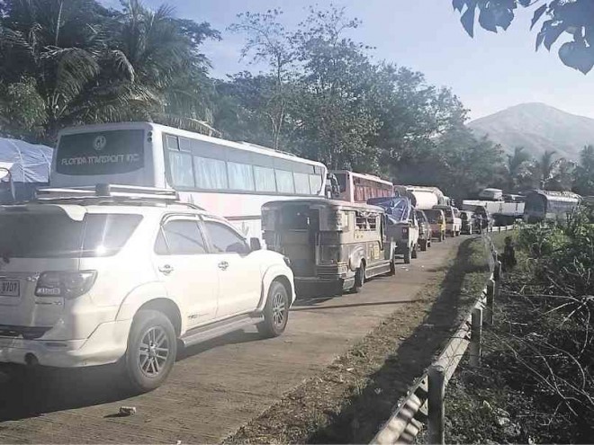 HUNDREDS of travelers are stuck for as long as 10 hours on the national highway at the boundary of the provinces of Nueva Vizcaya and Isabela at a road reblocking site in Barangay Caquilingan in Cordon town on Wednesday. Melvin Gascon/Inquirer Northern Luzon