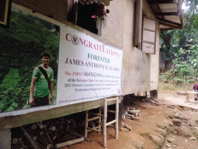 A TARPAULIN showing a message of congratulation to James Anthony Guarde for being the first Mangyan forester is displayed at their house at the foot of Mt. Halcon in Naujan. 