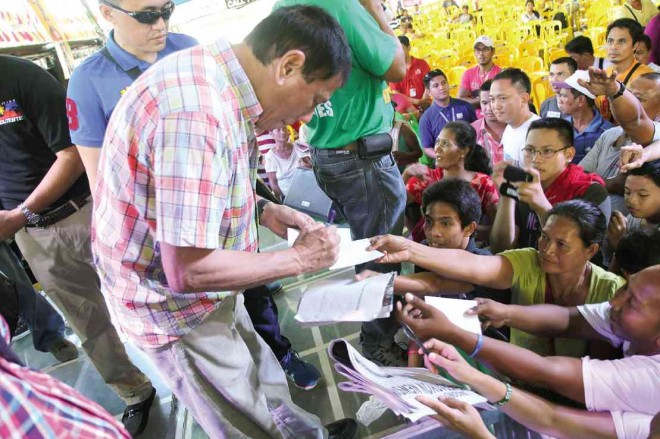DAVAO City Mayor Rodrigo Duterte signs autographs for admirers during a speaking engagement on Sunday in Lucena City. DELFIN T. MALLARI JR./INQUIRER SOUTHERN LUZON