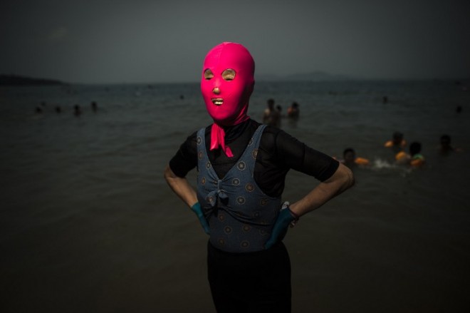  A woman wearing a facekini poses at the beach in Qingdao, eastern China's Shandong province on July 24, 2015. AFP PHOTO / FRED DUFOUR