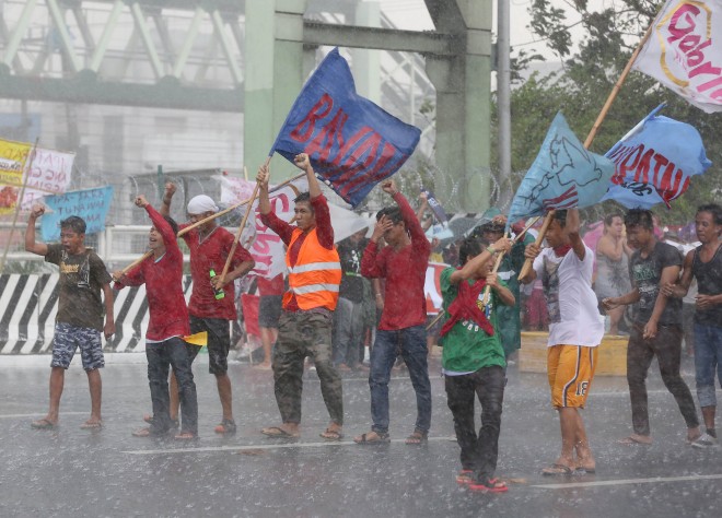 July 27, 2015 Protesters brave the rain as they are met by a downpour along Commowealth Ave., in Quezon City INQUIRER/ MARIANNE BERMUDEZ