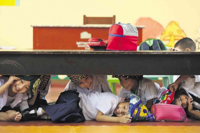 PLAYFUL QUAKE DRILL Kindergarten students practice the “duck, cover and hold” moves at Mandaluyong Elementary School in preparation for the Metro Manila Shake Drill scheduled today, and the Big One, which may hit the metropolis anytime. LYN RILLON