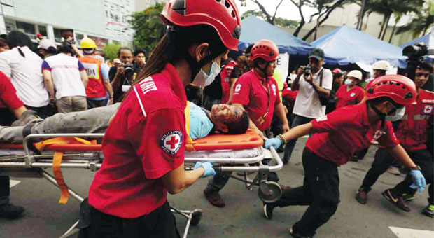 EVACUATING THE INJURED      Members of the Makati City rescue team evacuate an “injured” person from a building for treatment at a nearby medic staging area as part of simultaneous earthquake drills in Metro Manila in preparation for a 7.2-magnitude quake expected to hit the metropolis anytime. EDWIN BACASMAS