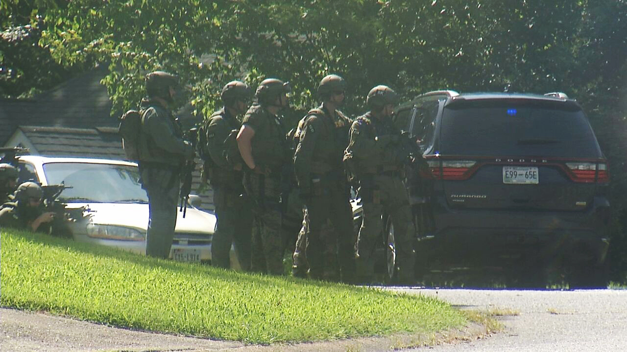 In this frame from video, law enforcement officers surround a house in Hixson, Tennessee, Thursday, July 16, 2015. A gunman unleashed a barrage of fire at two sites a few miles apart in Chattanooga, killing 4 Marines, officials said. The attacker was also killed.  AP PHOTO/ALEX SANZ