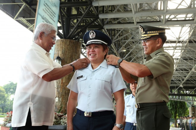  SND Voltaire Gazmin and Lt. Gen. Hernando DCA Iriberri, Chief of Staff AFP, attach the symbols of a Lieutenant Colonel to BIR Commissioner Kim Henares in her donning of ranks ceremony at Camp General Emilio Aguinaldo, Quezon City this morning (July 13). PHOTOS BY SSG AMABLE MILAY JR PAF