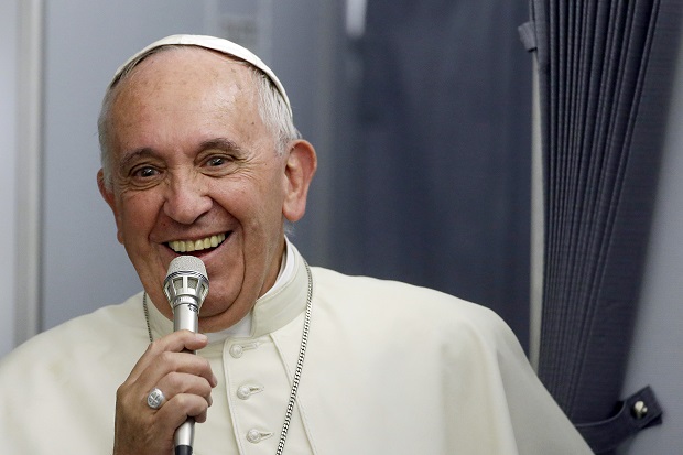 In this photo taken on Sunday, July 12, 2015, Pope Francis smiles as he meets the media during an airborne press conference aboard the airplane directed to Rome, at the end of his Apostolic journey in Ecuador, Bolivia and Paraguay. (AP Photo/Gregorio Borgia)