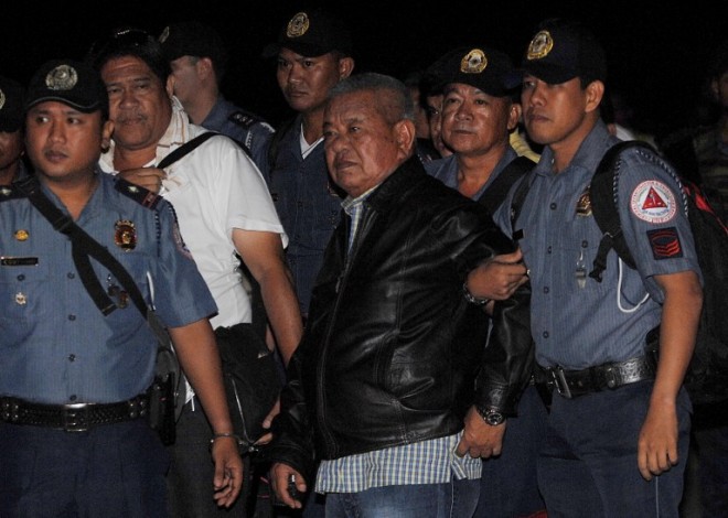 In this photo taken on April 16, 2010 former Governor of the Philippine province of Maguindanao Andal Ampatuan Senior (C) and four members of the Ampatuan clan are escorted by policemen as they arrive at the Villamor Airbase in Manila. Long-suffering widows of the Philippines' worst massacre said on July 18, 2015 that they have not forgiven a key suspect in spite of his death, as they repeated cries for justice. Andal Ampatuan Sr, who died on July 17 while battling liver cancer, should have lived to serve time in jail, the widows said.  AFP FILE PHOTO
