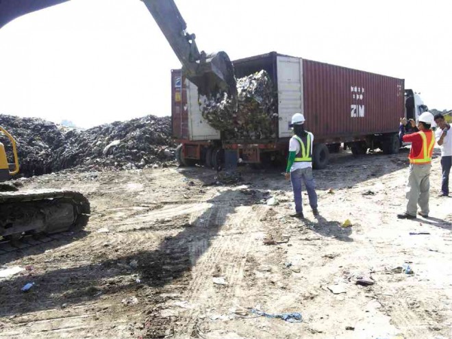 TRASH packed in containers that were shipped from Canada in 2013 are unloaded at the sanitary landfill of the Metro Clark Waste Management Corp. (MCWMC) in Capas, Tarlac province.  PHOTO COURTESY OF MCWMC 