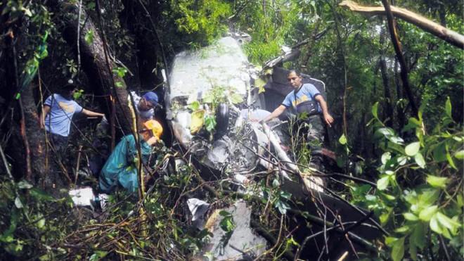 CHOPPER WRECKAGE  Probers examine the wreckage of the Augusta helicopter that crashed on Mount Maculot in Cuenca, Batangas province, on Sunday, killing billionaire Archie King and the pilot. A survivor said King switched off the engine moments before the helicopter crashed, preventing the aircraft from exploding.  ARNOLD ALMACEN