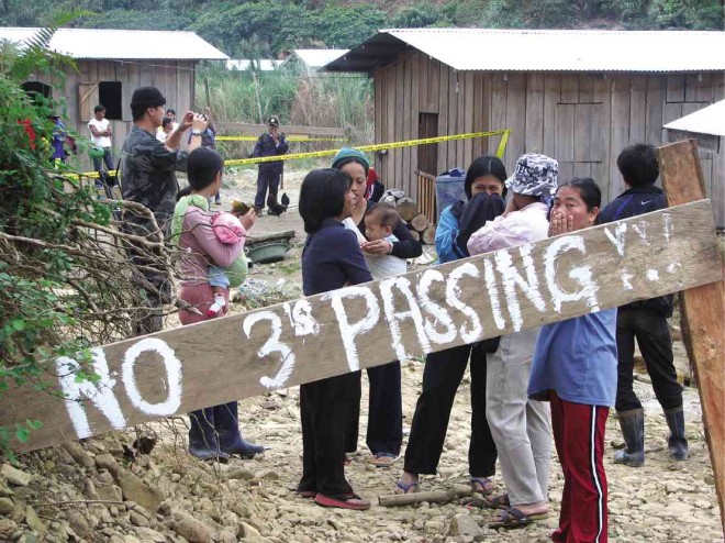 IN THIS 2008 photo, Ifugao residents of Barangay Didipio in Kasibu, Nueva Vizcaya province block attempts by OceanaGold Philippines Inc., an Australian mining firm, to enter their lands and demolish their houses. But after they were paid and the gold-copper mining project was allowed to start commercial operations in 2013, many of them, unguided on how they would manage their money, have fallen victims to an investment scam. MELVIN GASCON/INQUIRER NORTHERN LUZON 