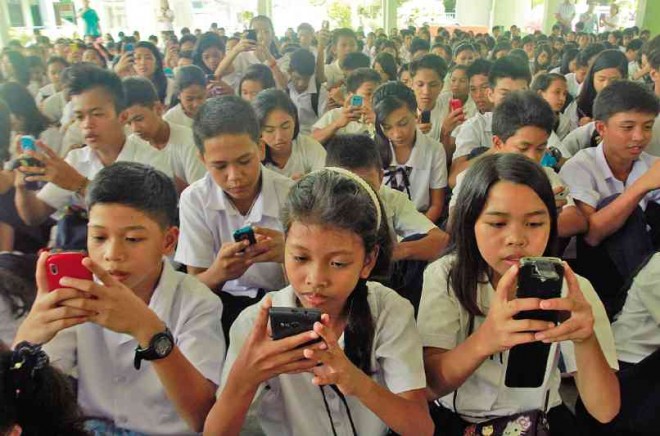 PAG-ASA National High School students save emergency hotline numbers on their cell phones as a disaster safety measure in Rawis, Legazpi City, Albay province, on Wednesday. MARK ALVIC ESPLANA/INQUIRER SOUTHERN LUZON.