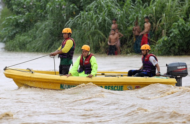 MARIKINA RIVER/JULY 7,2015 Rescue workers search the Marikina River for the body of Jozar Fazon who was reportedly swept by strong currents due to days of heavy rain after he was picking vegetables along the banks of the river. INQUIRER PHOTO/RAFFY LERMA