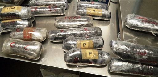 This Wednesday, June 10, 2015 photo provided by U.S. Customs and Border Protection shows 16 packages of methamphetamine and heroin found in a car being driven by two Mexican nationals at the U.S.-Mexico border port of entry in Nogales, Ariz. AP