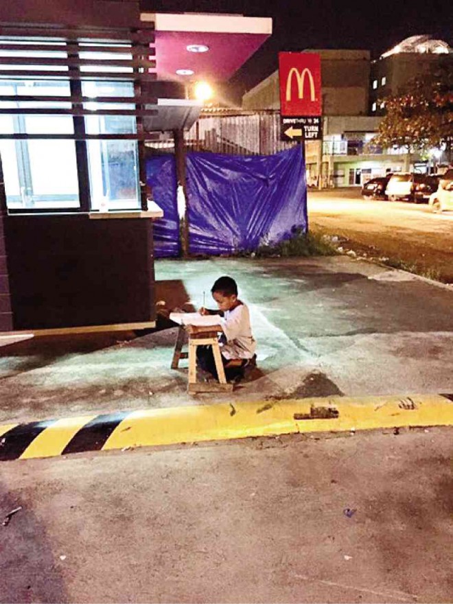 THIS PHOTO of Daniel Cabrera doing his homework (right) on a parking lot of a fast-food chain in Mandaue City has gone viral and led to small donations to the boy. The bench he uses is from the food stall where his mother works and he and his brothers also sleep in. 