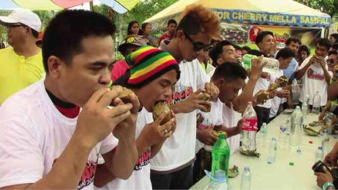 MEN line up in the “kalamay”-eating contest of the Pulang-Angui Festival on June 28. Kalamay is made of hardened sugarcane juice and coconut milk molded in half of a coconut shell. MICHAEL B. JAUCIAN
